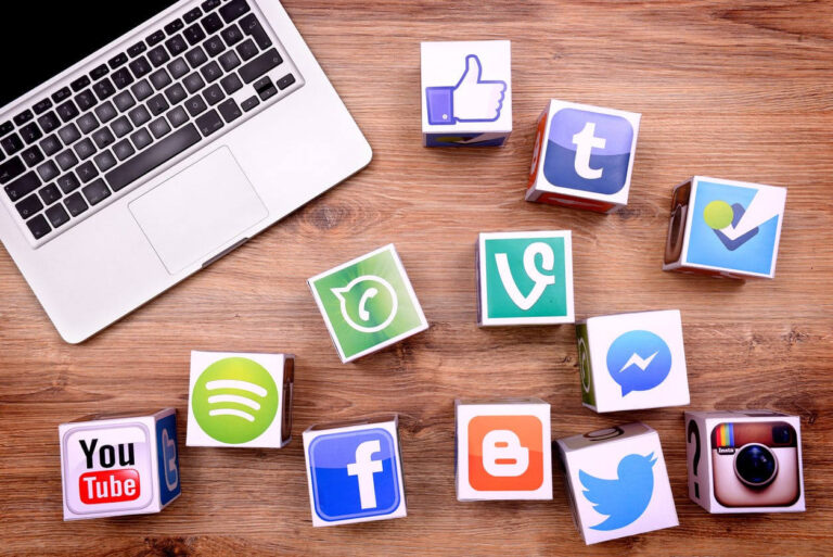 Social media icons laying next to the laptop part