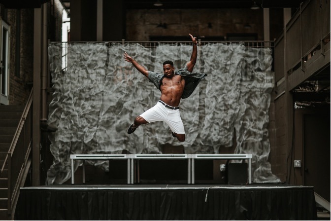 Man raising his both hands while on air in front of stage