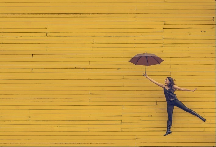 Woman holding brown umbrella