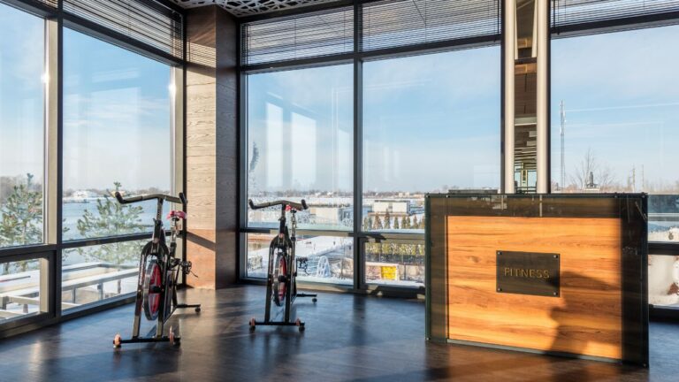 two bike machines placed near panoramic windows of contemporary gym