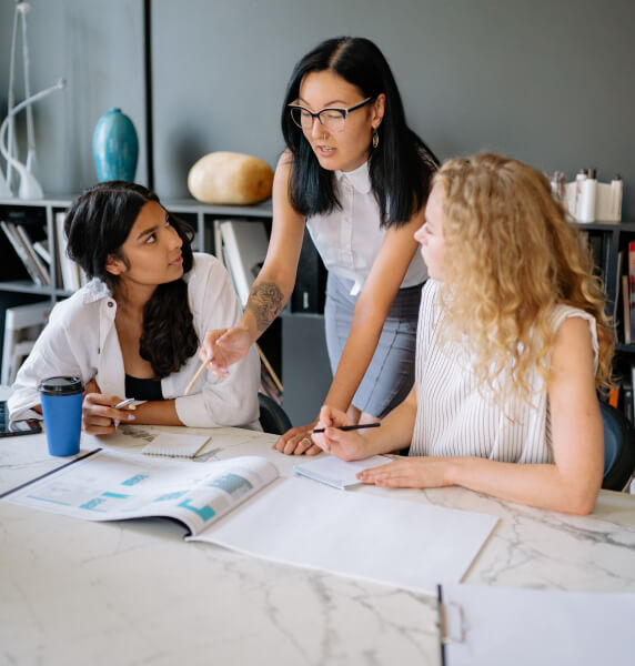 Three women in the office discussing business plans