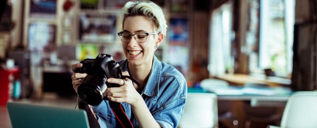 Photographer smiling at camera with laptop open in front of her